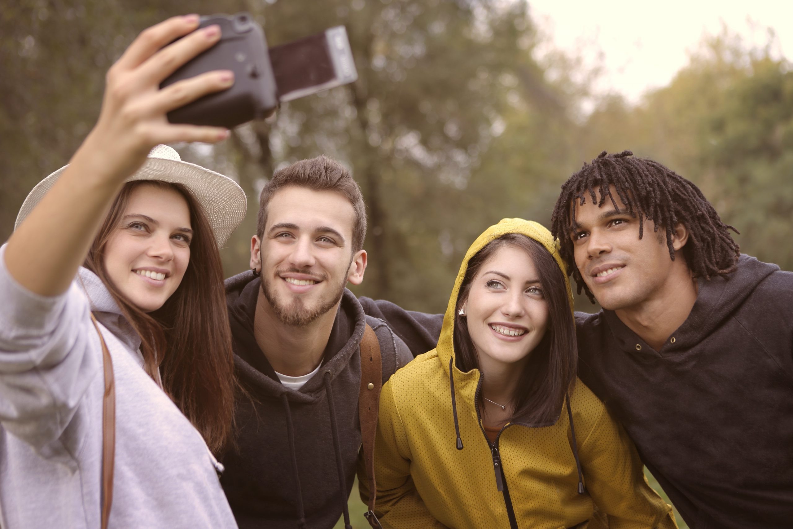 Group of young adults taking a selfie in nature.